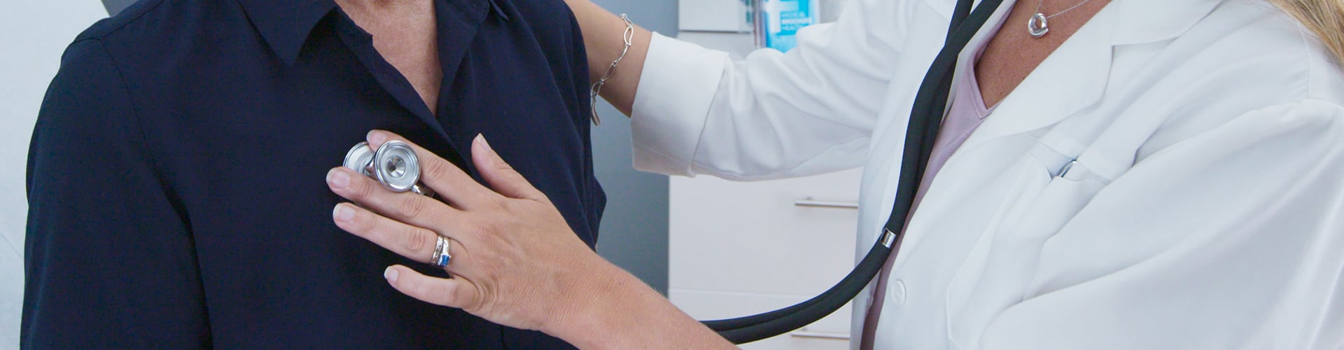 Doctor holding stethoscope to patient