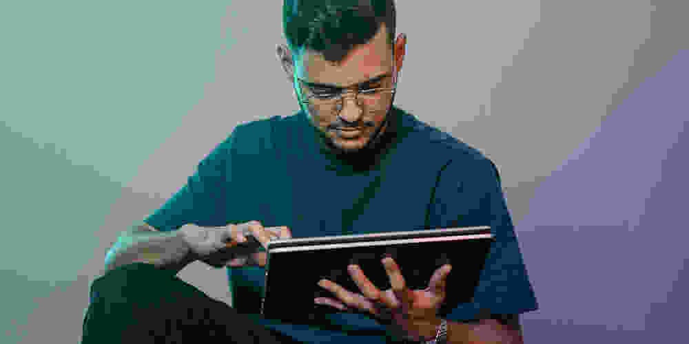 Young man scrolling on tablet