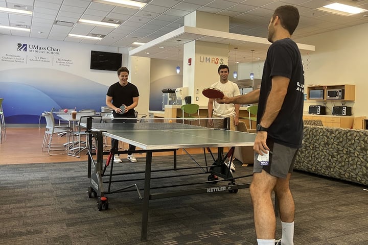 Students playing ping pong in Student Lounge.