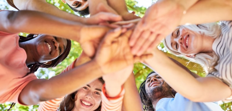 Group of young adults with hands in