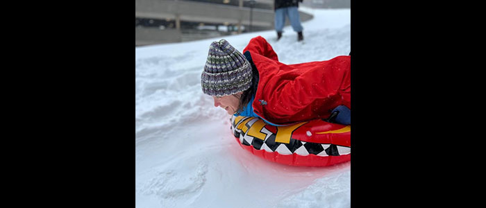 Dr. jessica Simons, Program Director sliding down a hill at UMass Chan