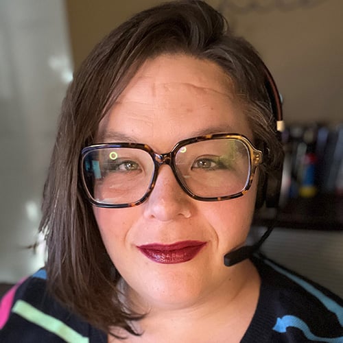 white woman with short dark hair and glasses smiling