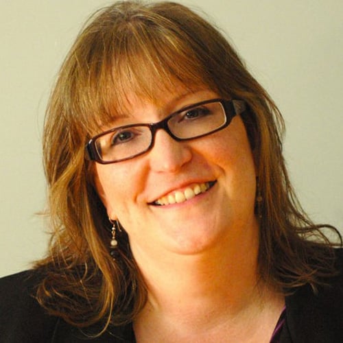 white woman with reddish hair and glasses