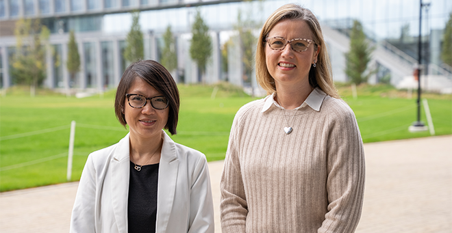 Khanh-Van T. Tran and Brigid M. Carlson standing together outside in front of a green lawn