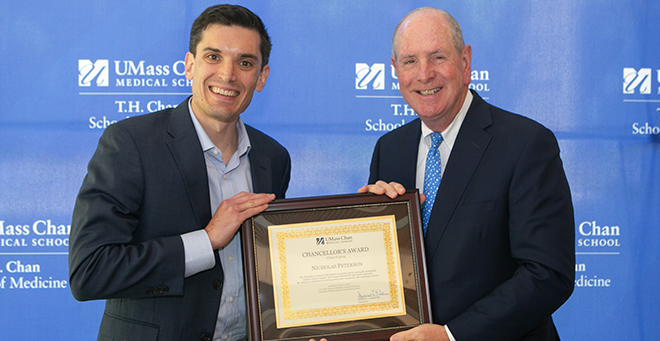 Photo with Nicholas Peterson and Chancellor Collins in front of banner